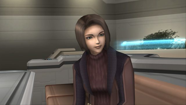 Xenosaga screenshot of Juli Mizrahi, a woman with short brown hairwearing a black and maroon sweater and vest, in a futuristic common room.