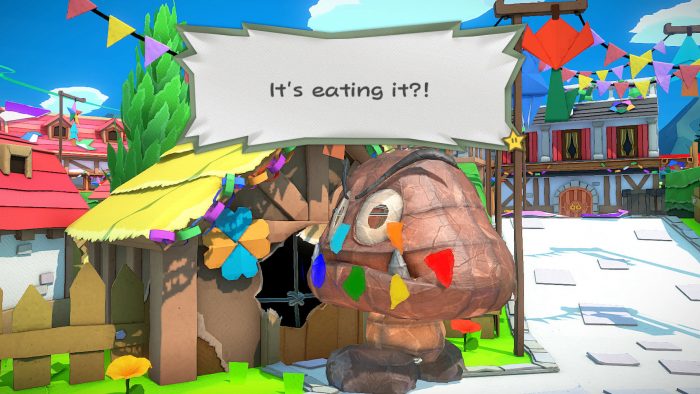 Paper Mario: The Origami King screenshot of a paper mache Goomba eats a house in the Mushroom Kingdom.