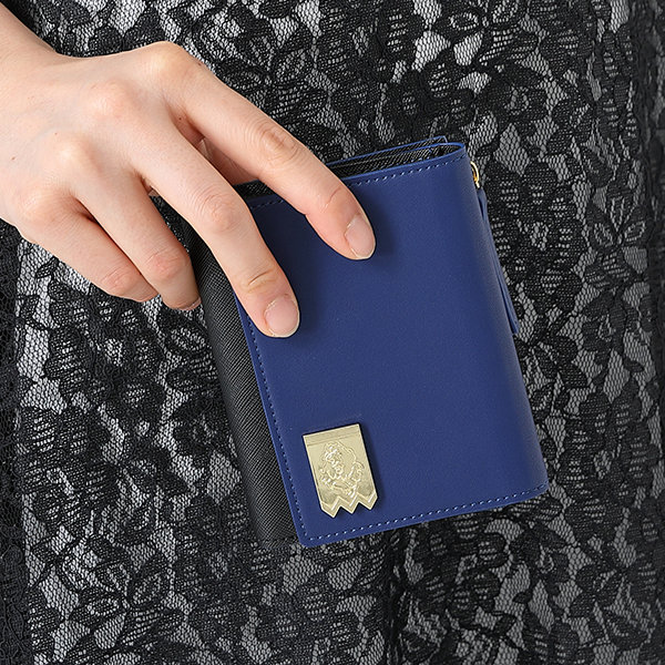 SuperGroupies Fire Emblem Three Houses Closeup of blue leather wallet being held near a black lace dress