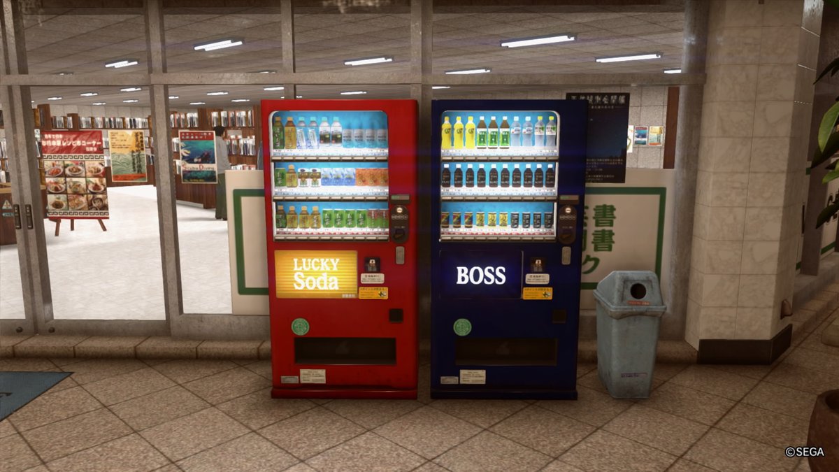 A pair of vending machines at the entry to a store: a red Lucky Soda machine on the left and closest to the door, and Boss Coffee on the right.