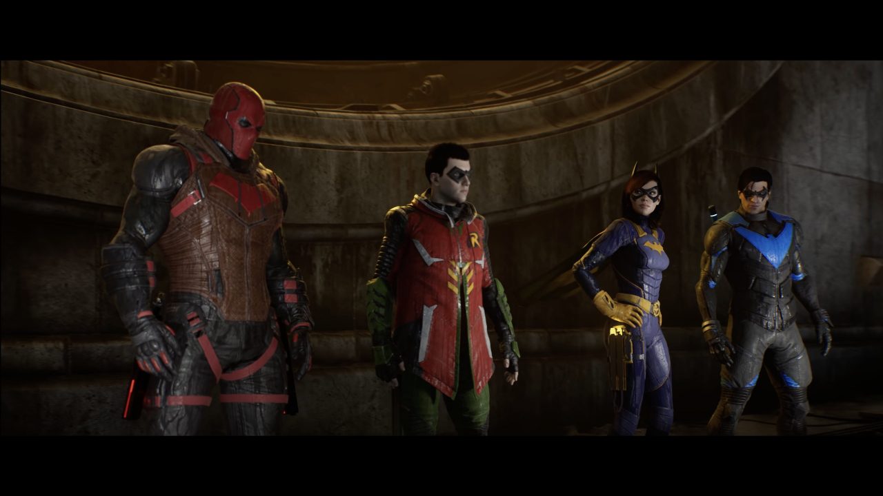 A Screenshot From Gotham Knights Featuring Red Hood, Nightwing, Robin, and Batgirl Lined Up