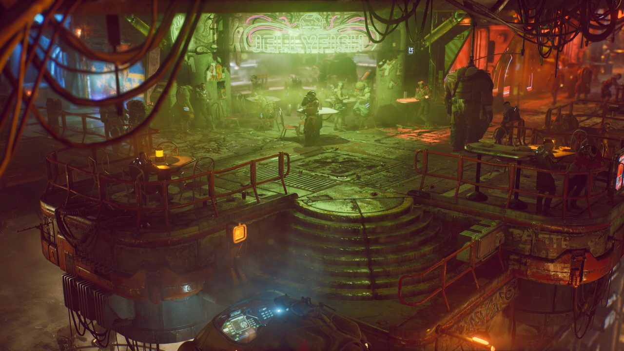 Outdoor seating in The Ascent under a neon Jellyfish sign.