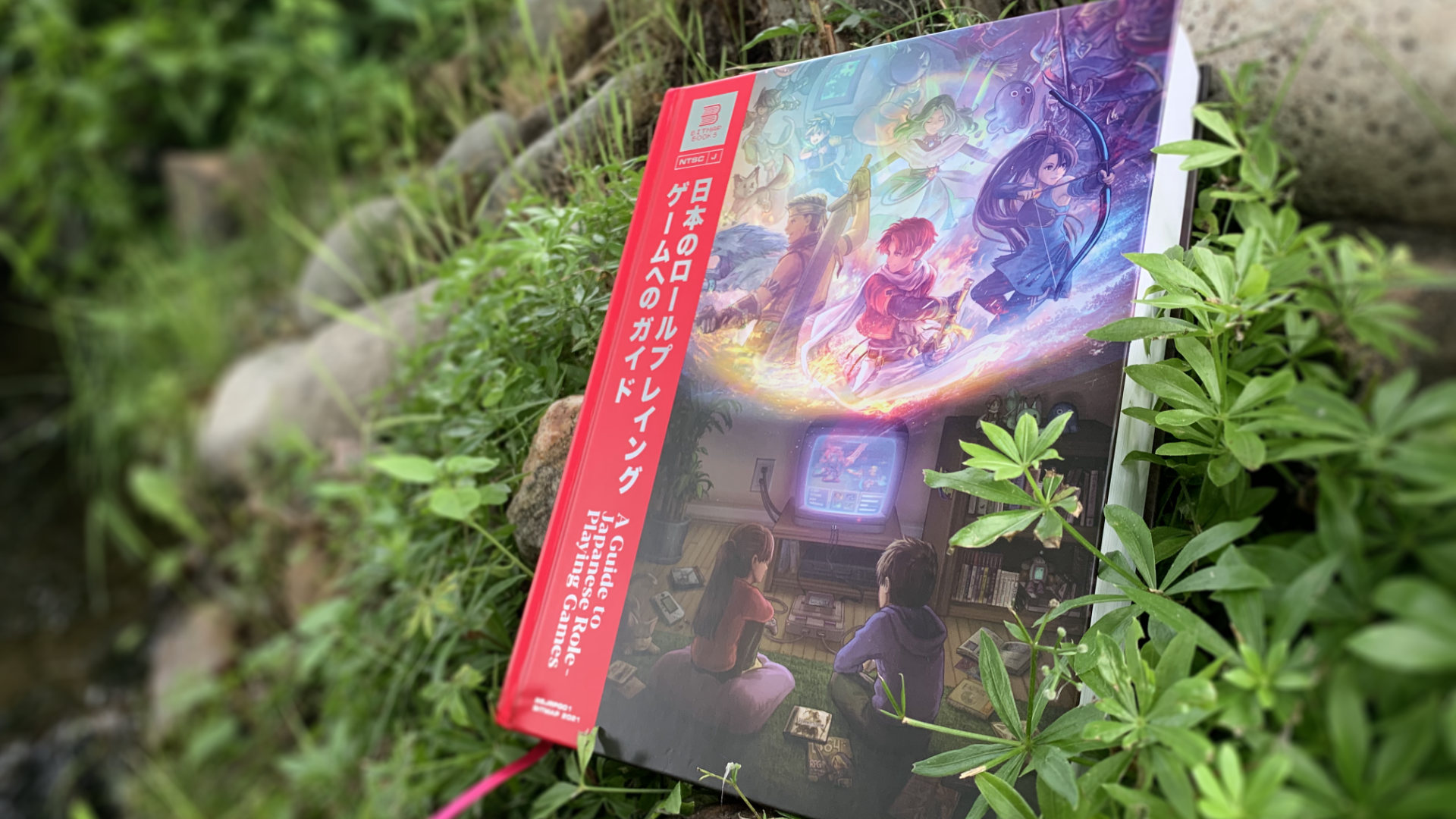 A Guide to Japanese Role-Playing Games against a verdent plant backdrop, with a little stream to the left.