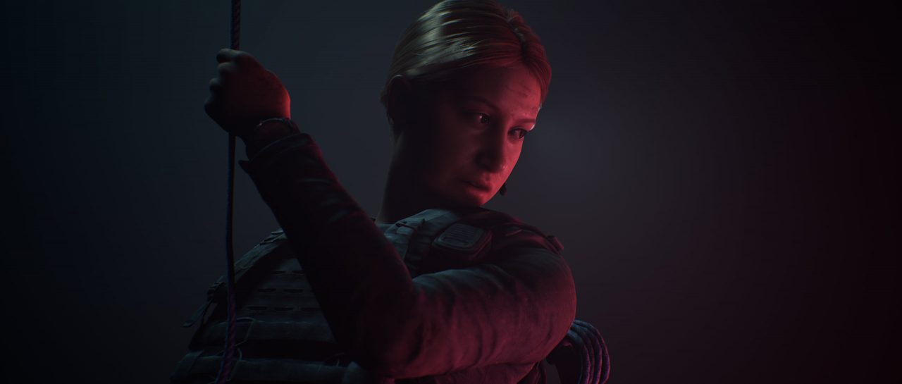 The Dark Pictures Anthology House of Ashes Screenshot of a woman in tactical gear descending a rope into darkness, dimly lit from one side.