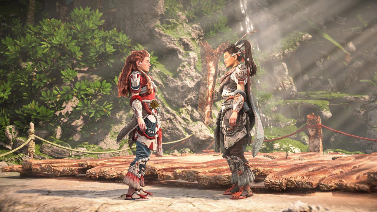 Horizon Forbidden West: Burning Shores screenshot of Aloy (left) and Seyka (right) standing facing each other, smiling, during a conversation.