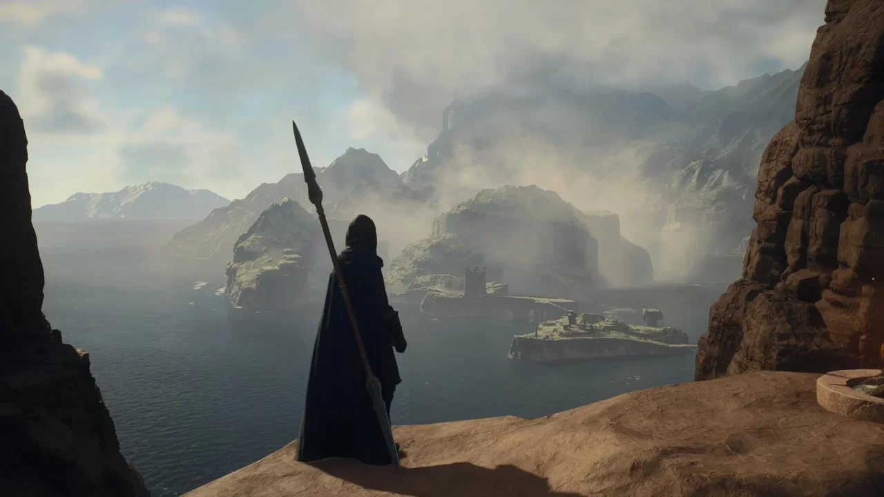 A hooded character with a spear stands on a cliff that overlooks a foggy citadel in Dragon's Dogma 2.