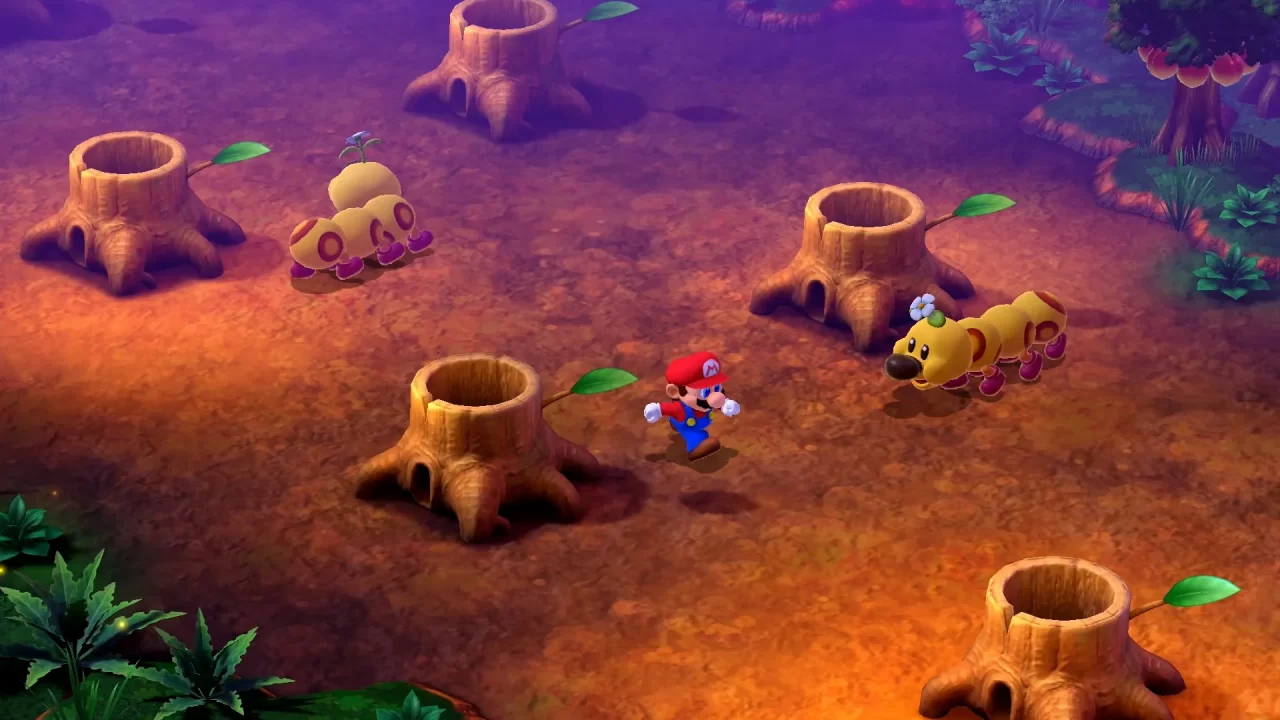 Screenshot of Super Mario RPG Remake showing Mario running through a forest in between a series of tube-like tree stumps while two wigglers roam nearby.