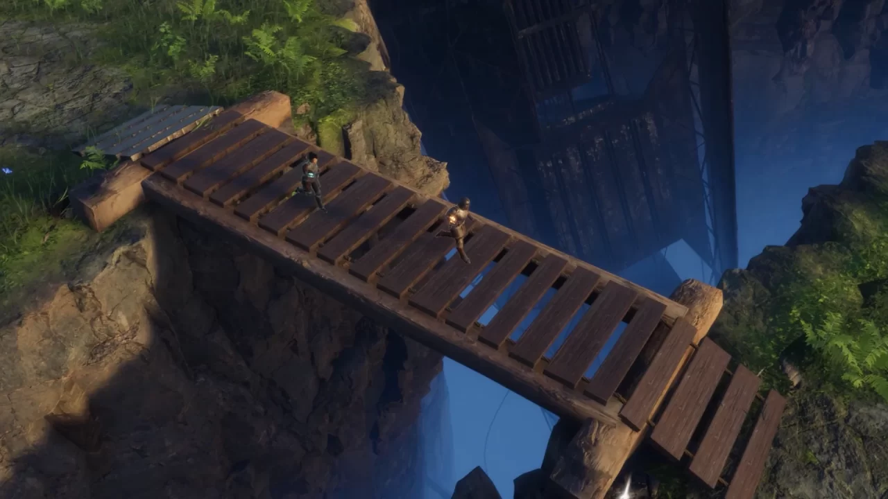 Two people walk across a wooden bridge spanning a gap between cliffs.