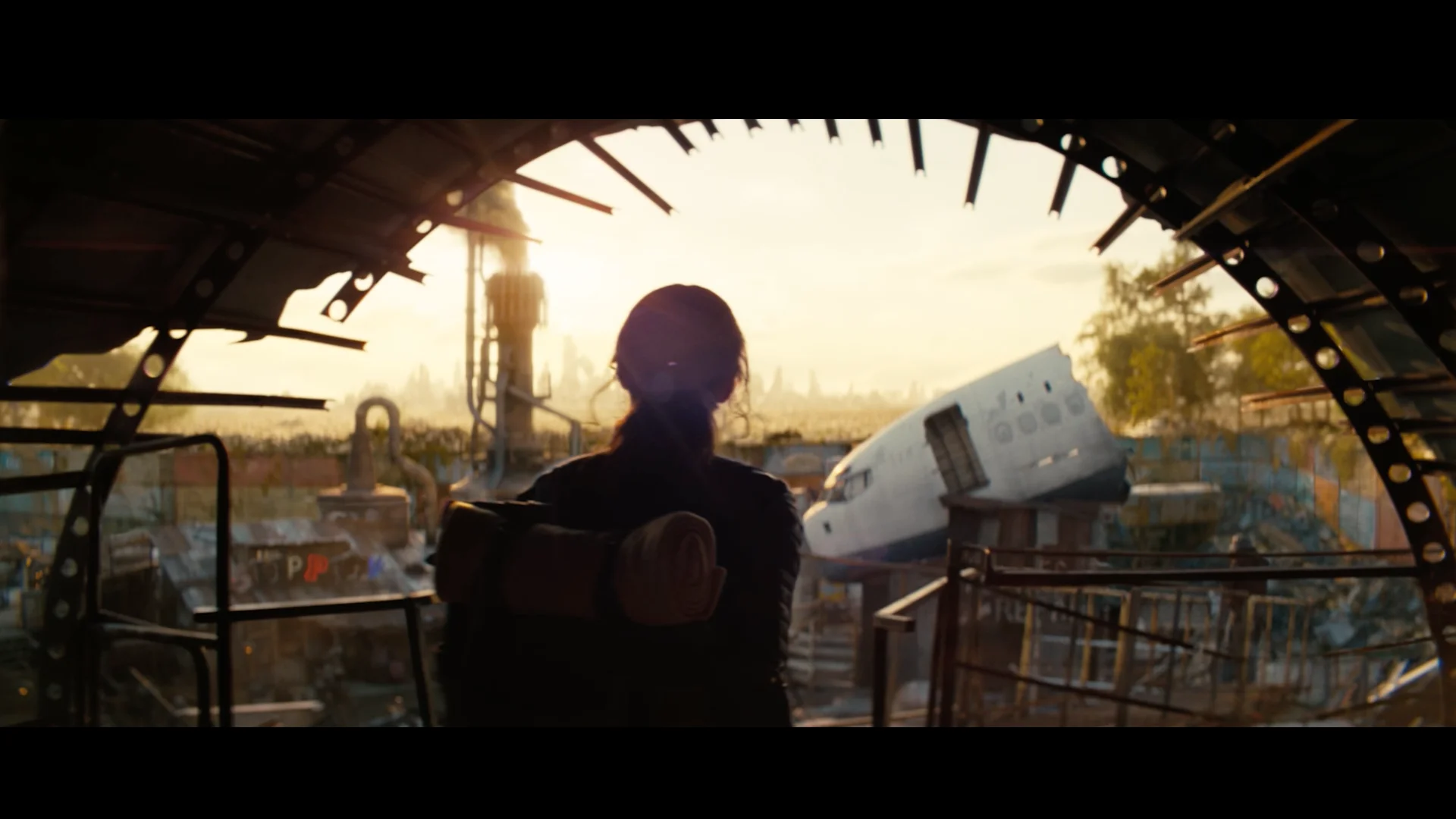 Fallout TV show still of a woman walking out on a landscape covered in wreckage