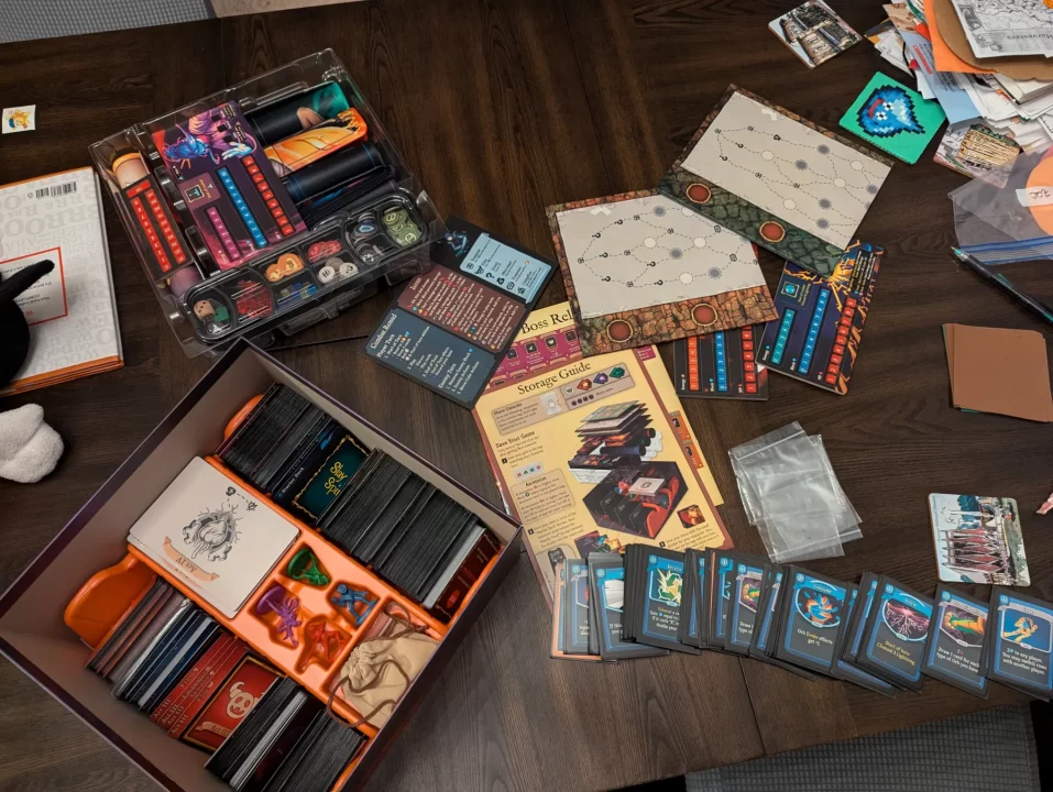 Slay the Spire The Board Game photo showing the many contents of the box - cards, tokens, bags, and more