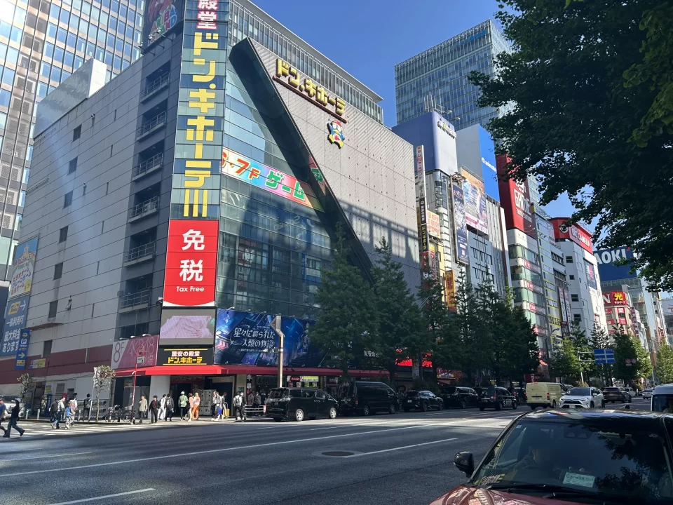 Photo of a main street in Akihabara. A large Don Quijote store stands on the opposite side of the street.