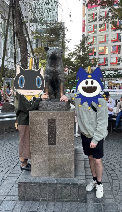 Photo of two people posing in front of the famous HachikĆ dog statue.