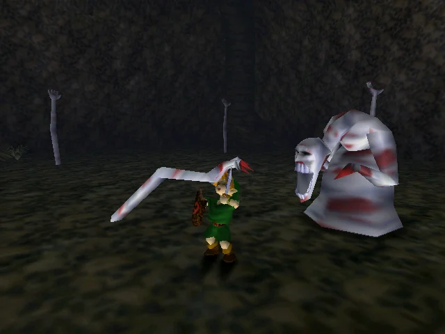 A screenshot from The Legend of Zelda: Ocarina of Time where Young Link is fighting the boss of the well, Dead Hand, a gruesome red and white creature with long hands that catch Link and hold him in place.