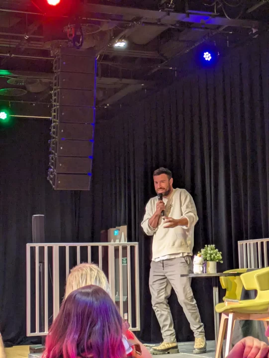 Ben Starr on stage hosting trivia at The Colors of Harmony.